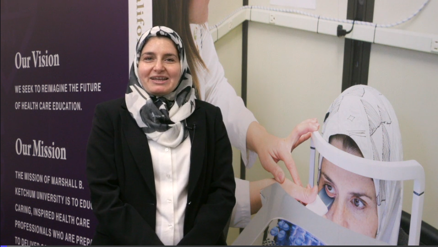 Photo of Dr. Khankan in front of Mural